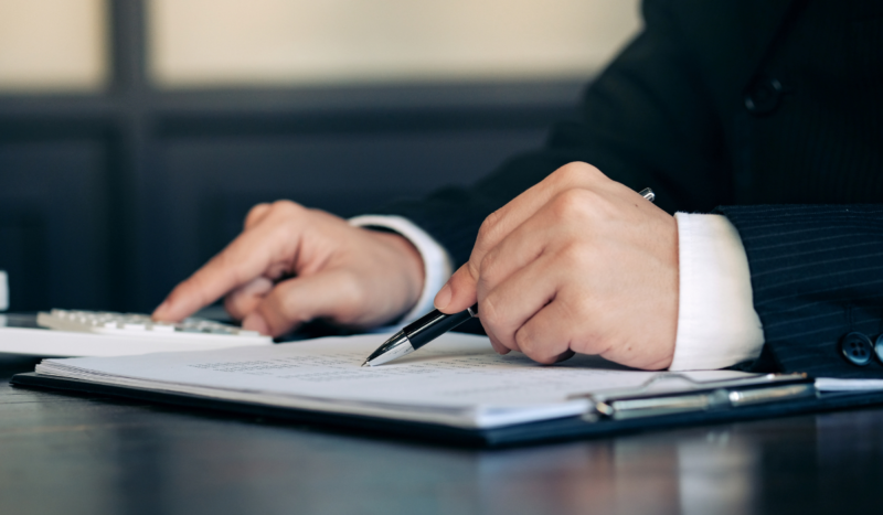 Professional signing documents at a desk